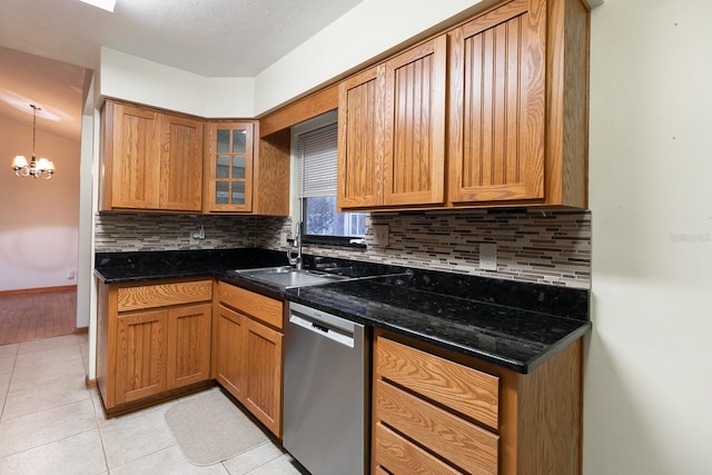 kitchen with backsplash, an inviting chandelier, stainless steel dishwasher, and sink