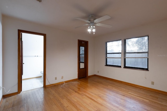 empty room with ceiling fan and light hardwood / wood-style flooring