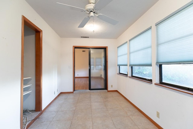 tiled empty room with ceiling fan