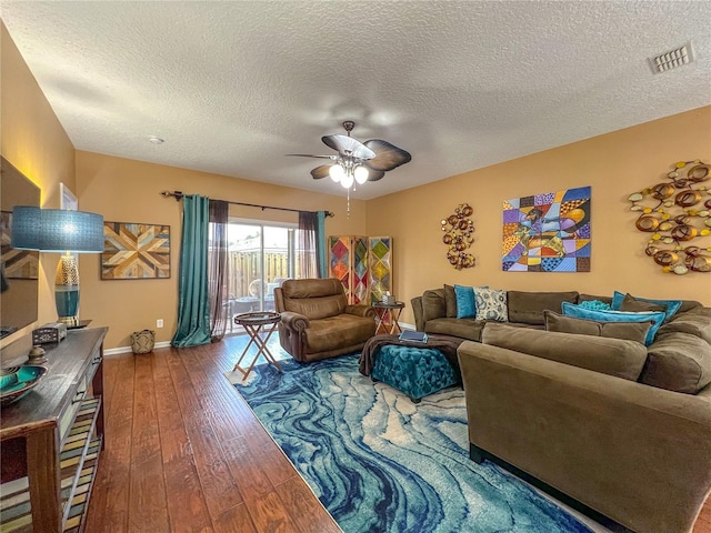 living room with ceiling fan, wood-type flooring, and a textured ceiling