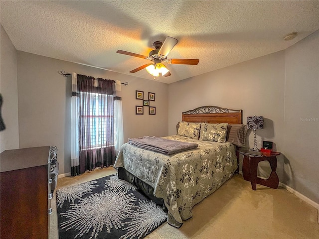 carpeted bedroom featuring ceiling fan and a textured ceiling