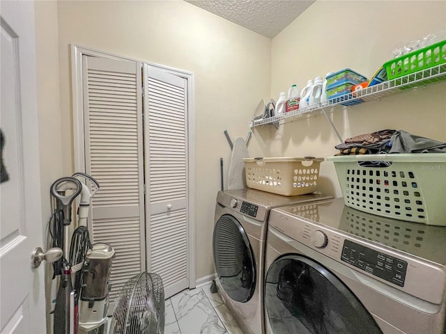 clothes washing area with a textured ceiling and independent washer and dryer