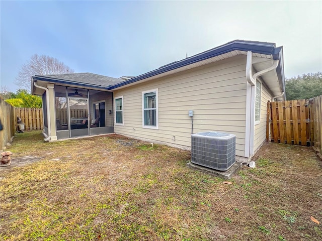 rear view of property featuring ceiling fan, central AC unit, and a sunroom