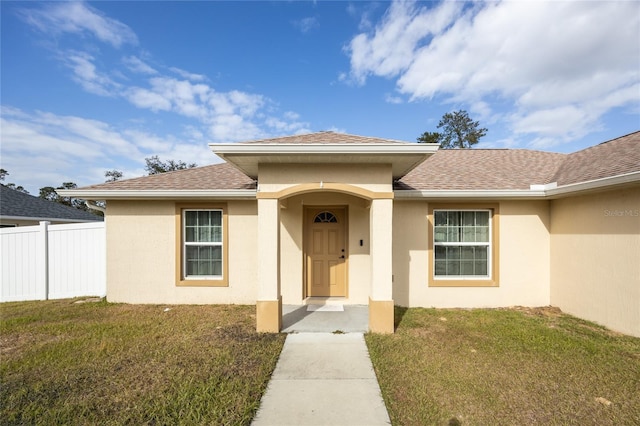 view of exterior entry featuring a yard