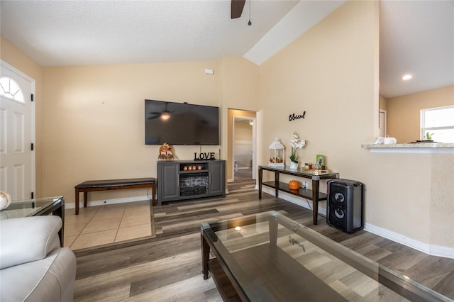 living room with a textured ceiling, ceiling fan, lofted ceiling, and hardwood / wood-style flooring