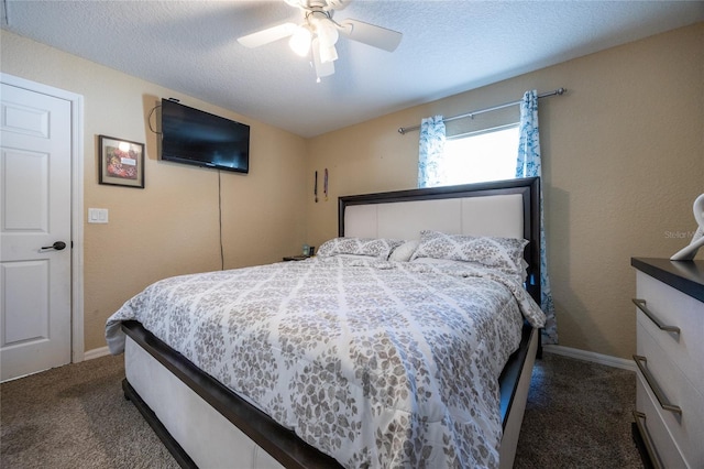 bedroom with ceiling fan, dark carpet, and a textured ceiling