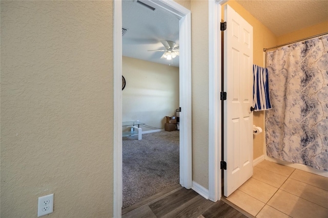 hallway with light tile patterned flooring and a textured ceiling