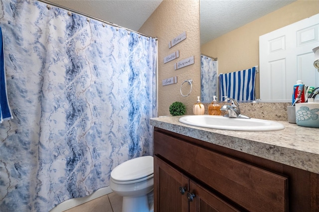 bathroom with vanity, tile patterned floors, a textured ceiling, and toilet