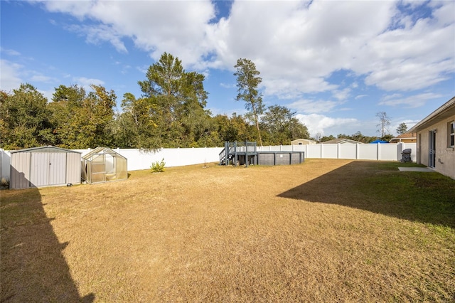 view of yard with a pool and an outdoor structure