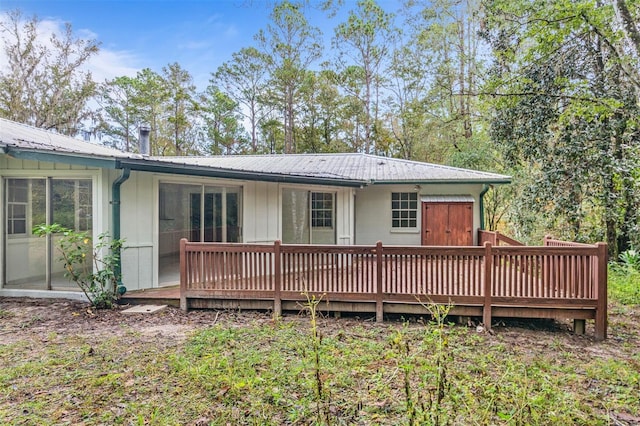 back of house with a wooden deck and a sunroom