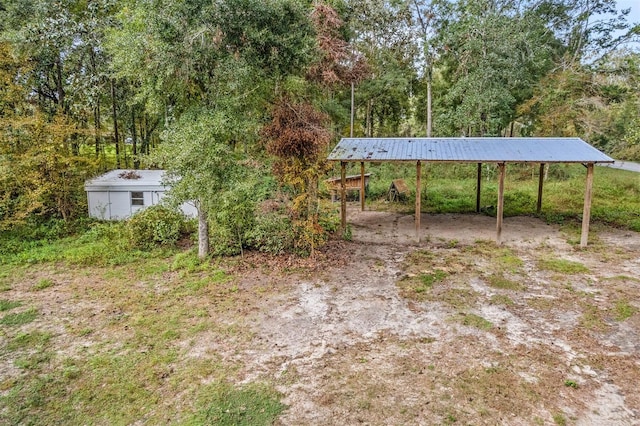 view of yard with a carport and a storage shed