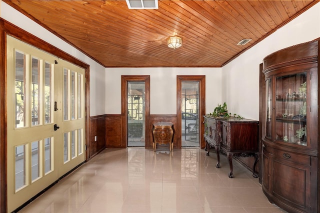 interior space featuring wood ceiling, wood walls, ornamental molding, and light tile patterned flooring