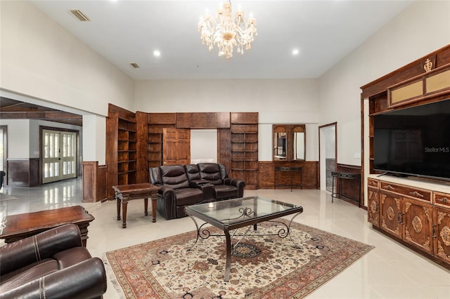 living room featuring a high ceiling, light tile patterned floors, and an inviting chandelier