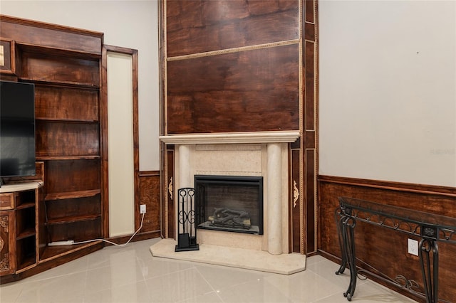 unfurnished living room featuring light tile patterned floors and wood walls