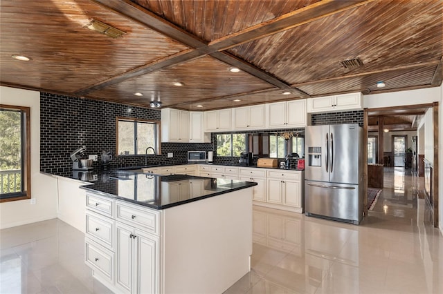 kitchen featuring stainless steel fridge, white cabinets, backsplash, light tile patterned floors, and wooden ceiling