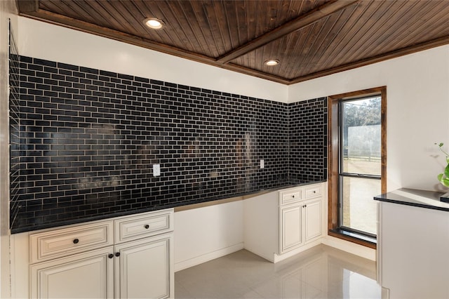 kitchen with cream cabinetry, light tile patterned floors, wood ceiling, ornamental molding, and built in desk