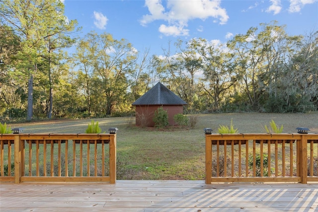 wooden deck with a yard and a storage shed