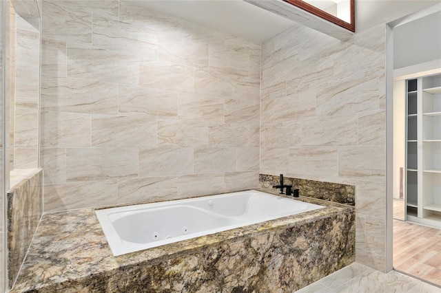 bathroom with tile walls and tiled tub