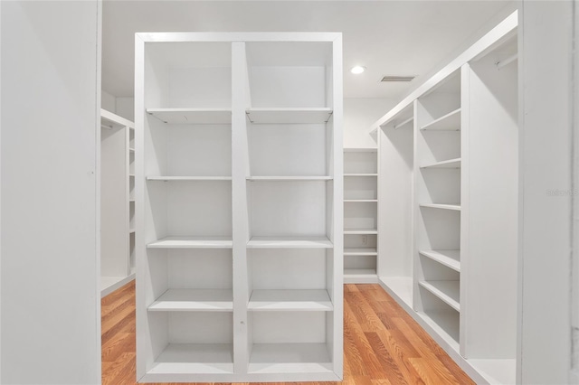 spacious closet with hardwood / wood-style flooring