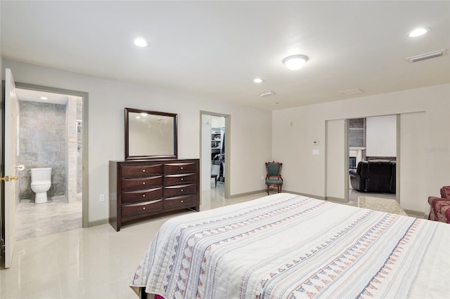 bedroom with a walk in closet, a closet, and ensuite bath