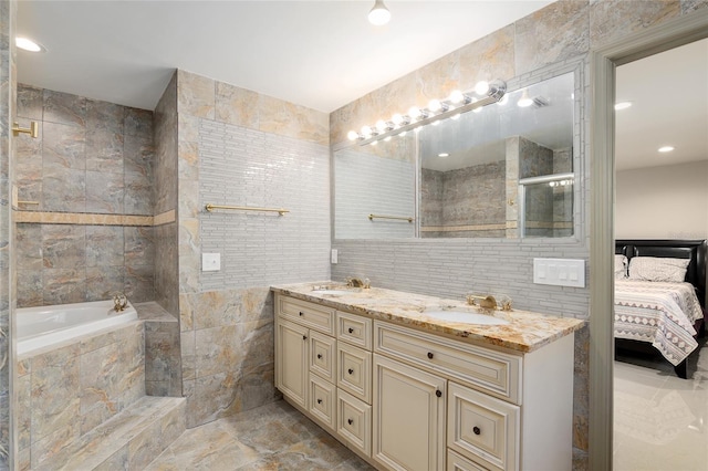 bathroom with vanity, tile walls, and a relaxing tiled tub