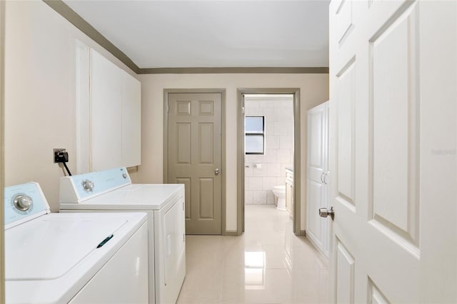 washroom with tile walls, light tile patterned floors, and washer and dryer