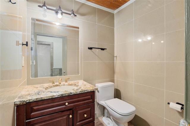 bathroom featuring vanity, toilet, tile walls, and crown molding