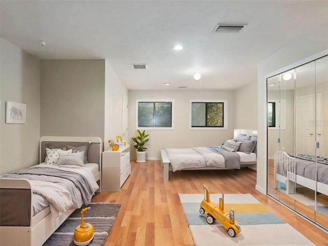 bedroom with light wood-type flooring and a closet