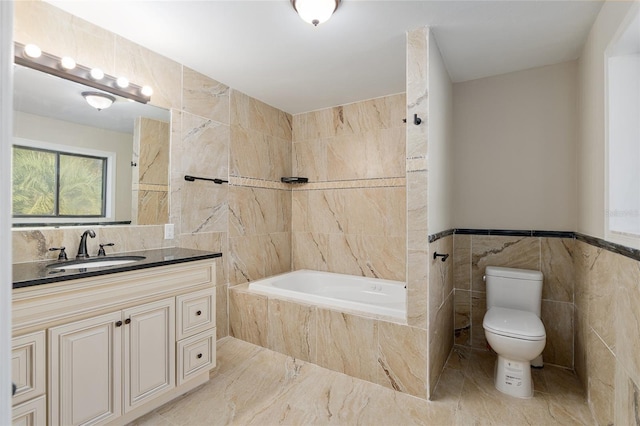 bathroom featuring toilet, vanity, tiled bath, and tile walls