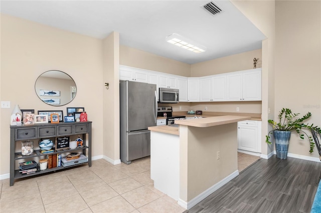 kitchen with a kitchen island, white cabinetry, and appliances with stainless steel finishes