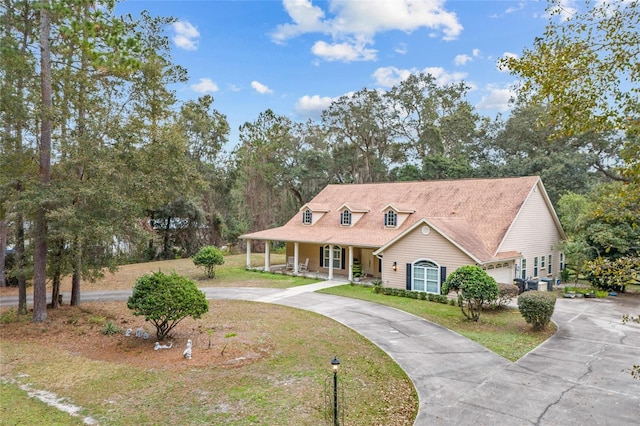 view of front of house with a porch, a garage, and a front lawn