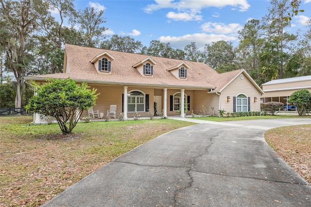 cape cod home with a front lawn