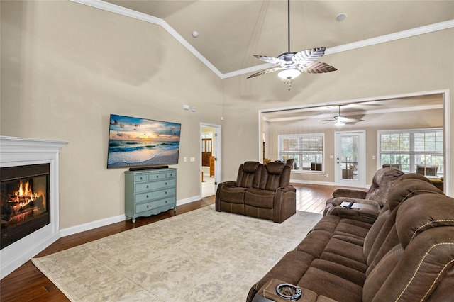 living room featuring dark hardwood / wood-style flooring, plenty of natural light, crown molding, and ceiling fan