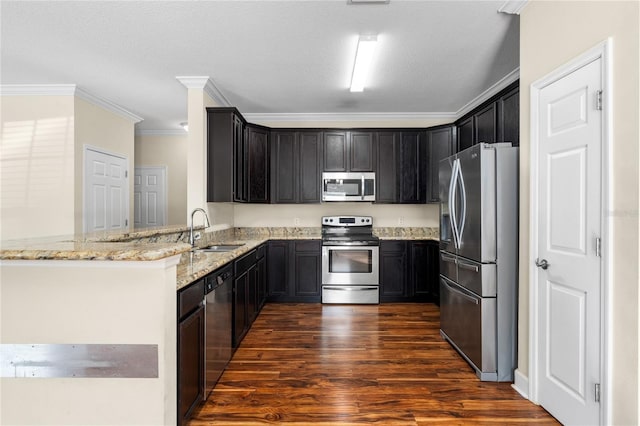 kitchen featuring light stone countertops, kitchen peninsula, ornamental molding, stainless steel appliances, and sink