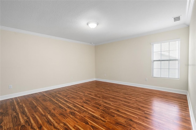 spare room featuring a textured ceiling, dark hardwood / wood-style floors, and ornamental molding