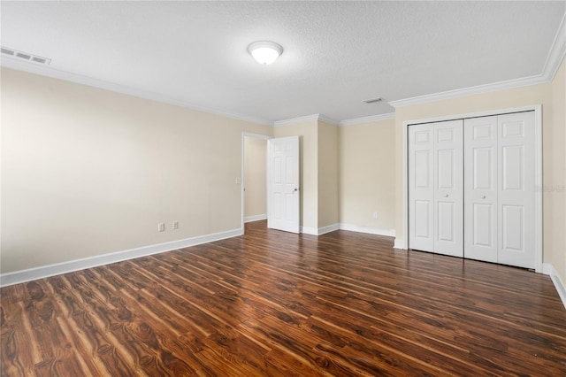 unfurnished bedroom featuring crown molding, a closet, and dark wood-type flooring