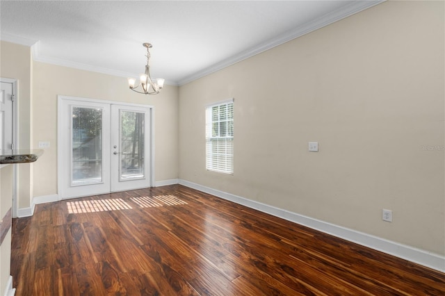 empty room with french doors, hardwood / wood-style flooring, ornamental molding, and a notable chandelier