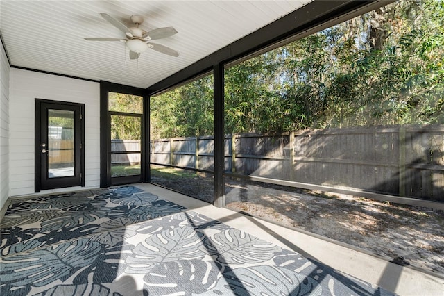 unfurnished sunroom featuring ceiling fan