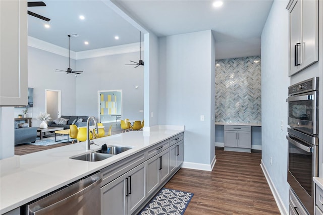 kitchen with appliances with stainless steel finishes, dark hardwood / wood-style flooring, ornamental molding, gray cabinetry, and sink