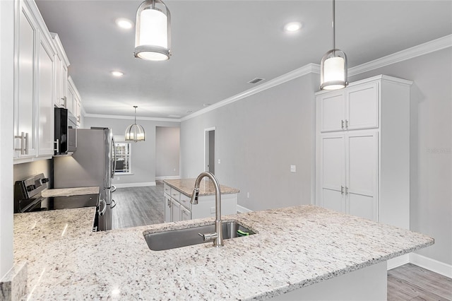 kitchen featuring white cabinetry, sink, stainless steel appliances, and decorative light fixtures