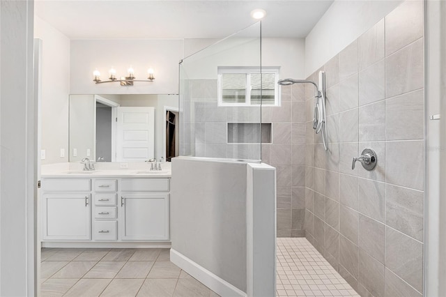 bathroom with a tile shower, tile patterned flooring, and vanity