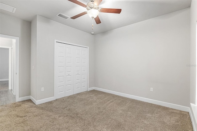 unfurnished bedroom featuring carpet floors, a closet, and ceiling fan