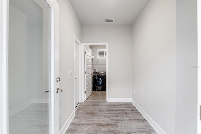 hallway featuring washer / dryer and light wood-type flooring