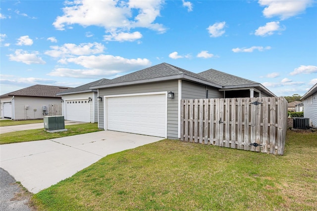 exterior space with a lawn, cooling unit, and a garage