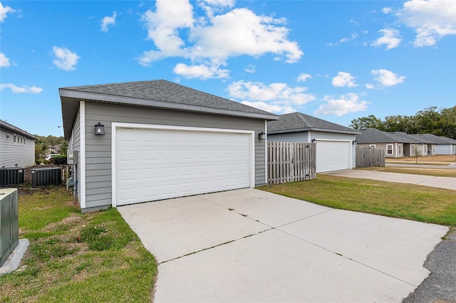 garage with a lawn and cooling unit