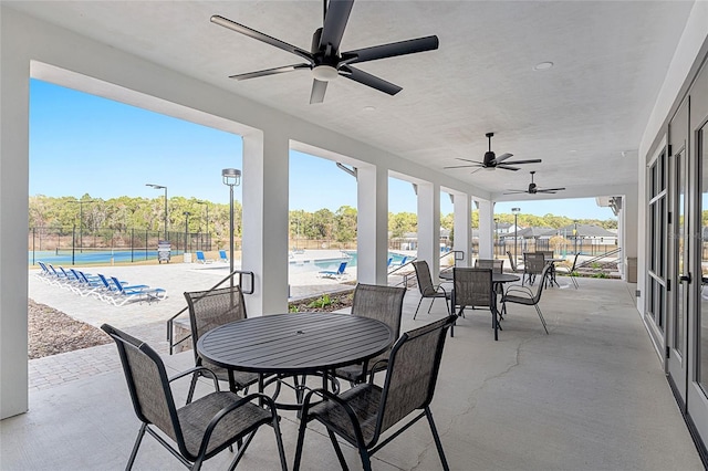 view of patio / terrace featuring a community pool and tennis court