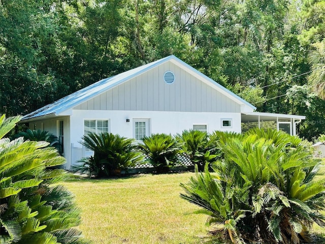 view of side of home with a yard