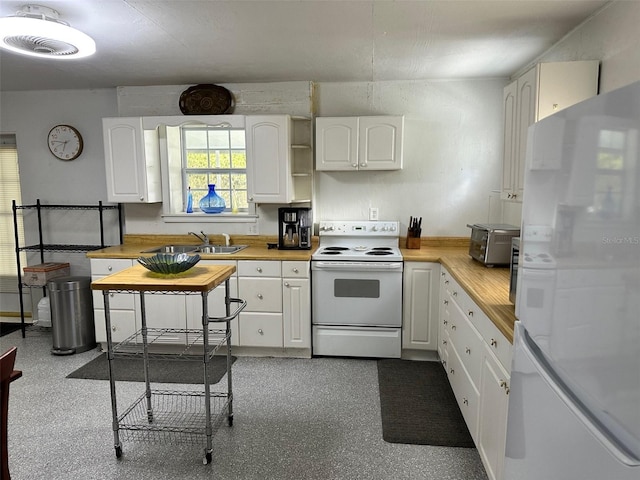 kitchen featuring sink, white cabinets, wooden counters, and white appliances