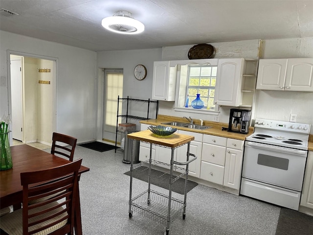 kitchen with white cabinets, white electric range oven, wood counters, and sink