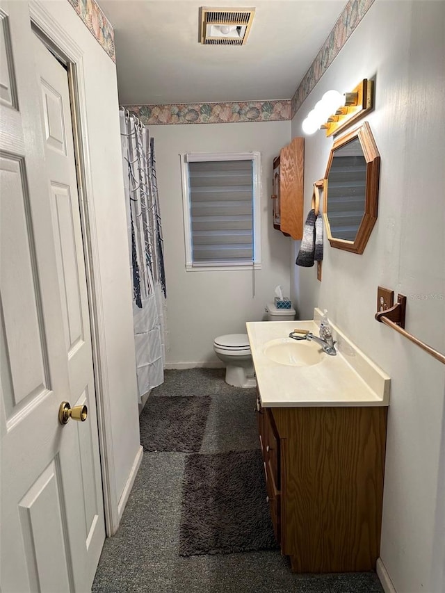 bathroom with vanity, toilet, and walk in shower